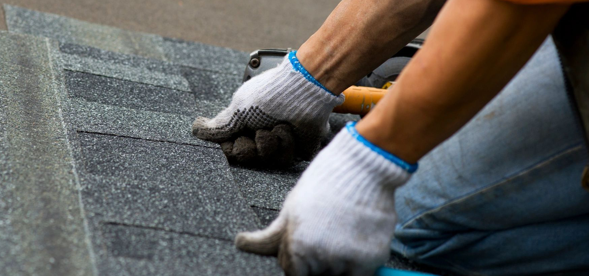 A person wearing white gloves on top of a roof.